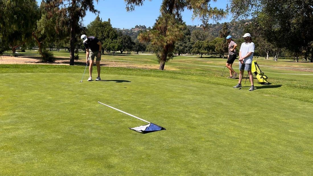 Golfer at the tee box with mountains in the background